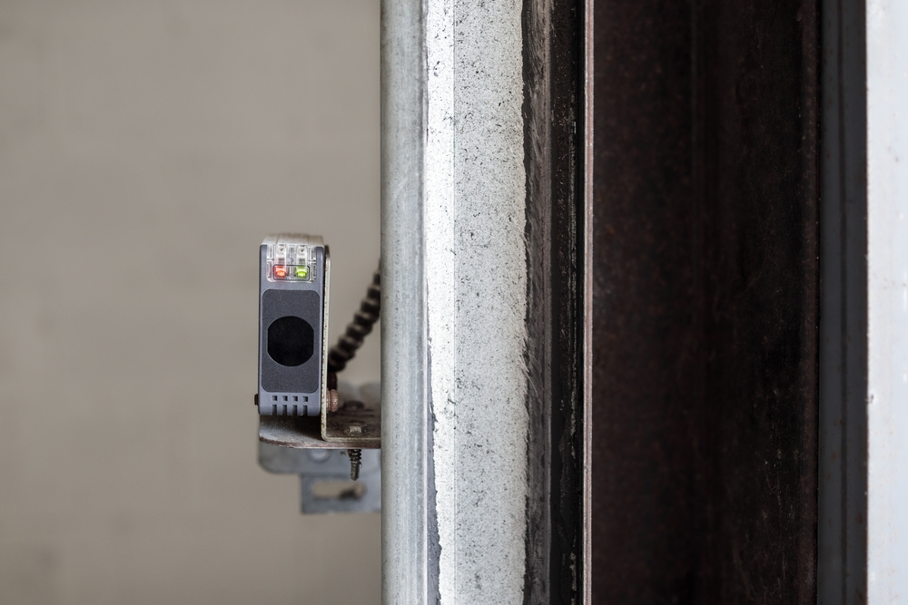 close-up of a garage door safety sensor mounted on a wall