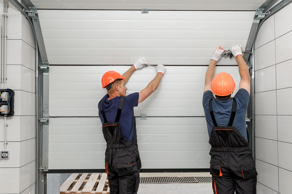 Professional installers replacing a residential garage door during a home improvement project