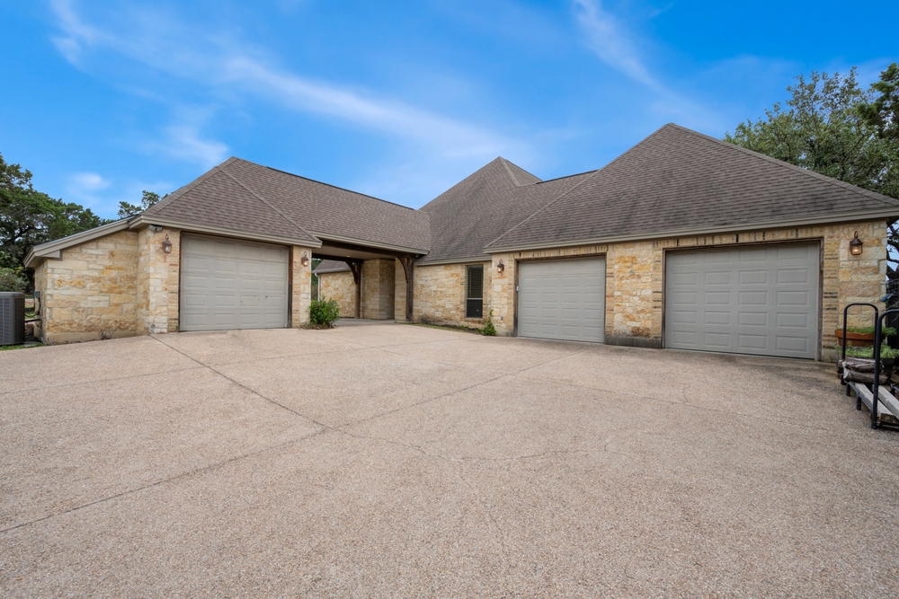 DallasTexas-May30th2023AHomeWithA Modern white garage door on the front of a brick Texas home with a concrete driveway.